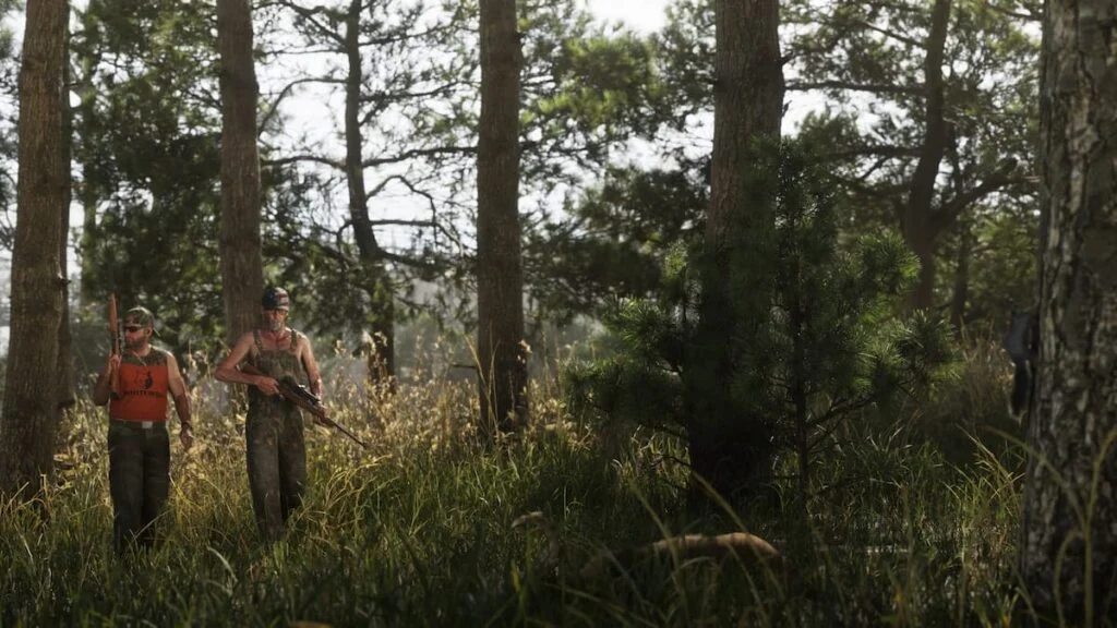 Two armed hunters moving through the woods